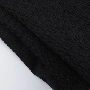 Detail of black pleated fabric texture for the corset crop top with sharp ruffles