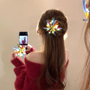Close-up of LED glowing colorful twist stick firework hair clip in a hair bun style