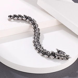 Dettaglio del bracciale maschile a lisca di drago con trama metallica punk vintage