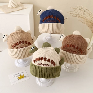 Detail showing various colors of dinosaur knit hats with 3D elements and cute embroidery