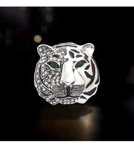 Macro view of crystal tiger head brooch with green gem eyes and black enamel stripes
