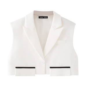 Dettaglio del gilet bianco con bordino a contrasto nero ed etichetta interna taglia M