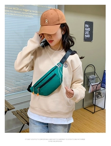 Detail view of green nylon waist bag with adjustable strap and side earphone port