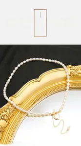 Close-up of natural freshwater pearl necklace with gold heart pendant and T-bar toggle clasp
