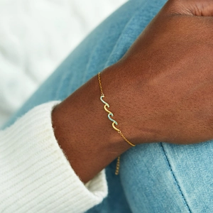 Adjustable wavy gold chain bracelet with inlaid blue crystals for a minimalist chic look