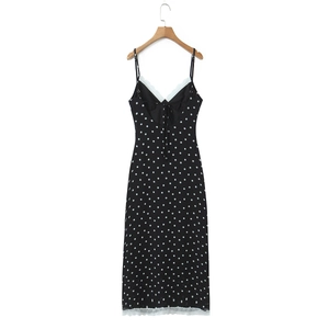Détail de robe noire à pois avec bordure en dentelle blanche au col et à l'ourlet