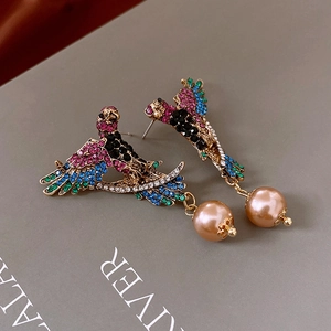 Detail of vintage bird earrings featuring colorful rhinestones and gold pearl drops