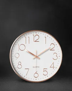 Detailed view of the rose gold metal frame and 3D numeric scale on the modern silent clock