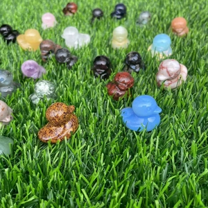 Detailed view of colorful carved gemstone ducks scattered across a natural green grass lawn