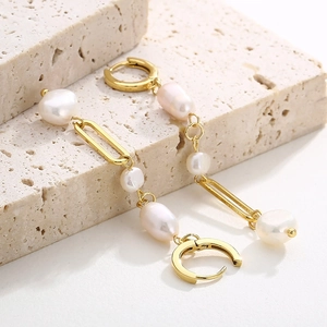 Détail macro de boucles d'oreilles vintage à perles sur un socle en pierre