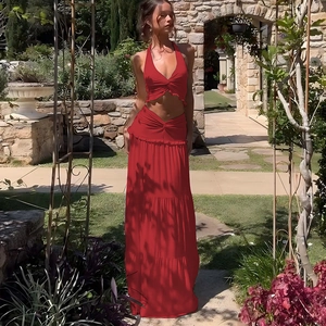 Detail of red two-piece halter crop top and ruffled maxi skirt in a sunlit garden