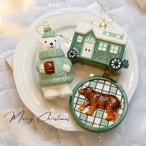 Three-piece turquoise and white Christmas bear and cabin ornaments on a decorative plate