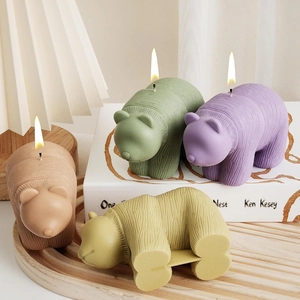 3D Bären-Duftkerze mit Webstruktur in vier Pastellfarben auf einem Holztablett