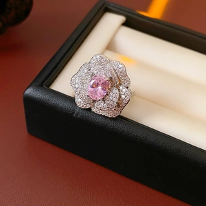 Close-up of sparkling floral ring with oval pink zircon in a premium jewelry gift box