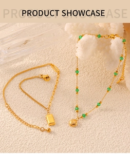 Detail of gold titanium steel anklet with green beads and shell pendant on white coral