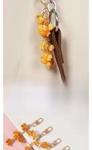 Realistic PVC popcorn keychain charm with metal lobster clasp on a stylish handbag