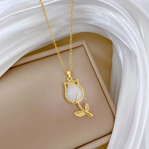 Macro shot of a gold tulip necklace with white petals on silk background