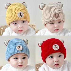 Winter knitted baby hats with bear ears in yellow beige blue and red colors