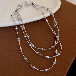 Détail d'un collier à plusieurs rangs en argent avec perles grises et maillons torsadés