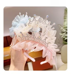 Close-up of lace mesh ruffles, rhinestones crown and pearls on a princess headband