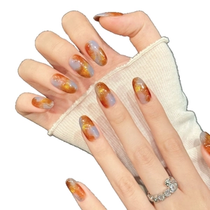 Orange and grey agate style press-on nails with gold foil accents on almond shape nails