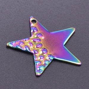 Gros plan d'un pendentif étoile en acier arc-en-ciel avec textures d'écailles et poli