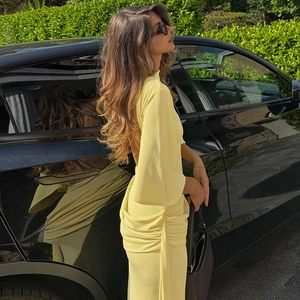 Detail of light yellow backless maxi dress featuring side ruching and elegant draping