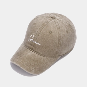 Close-up of the vintage washed khaki cotton baseball cap with white Groom embroidery detail