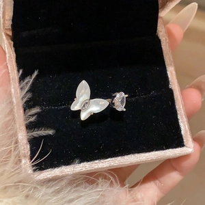 Detailed close-up of a butterfly zircon open ring resting on a pink velvet jewelry box
