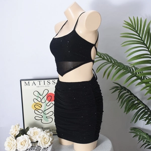 Detail eines schwarzen Glitzer-Zweiteilers mit Neckholder-Top und gerafftem Minirock