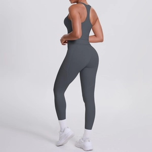 Detail of dark grey racerback sports bra and yoga pants with side pockets on model