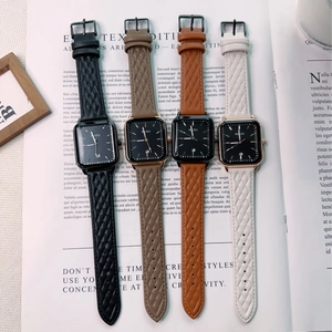 Flat lay view of four vintage square quartz watches with quilted leather texture straps