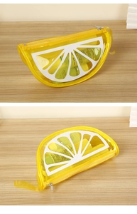 Close-up of yellow lemon-shaped PVC makeup bag with white textures and zipper strap