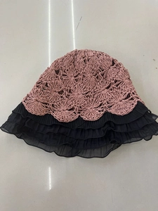 Close-up of pink crochet sun hat with triple-layered black pleated chiffon lace trim