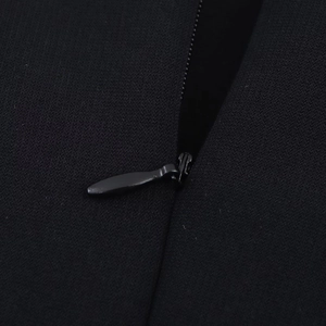Detail of the high-quality invisible zipper on a black knitted halter neck midi dress