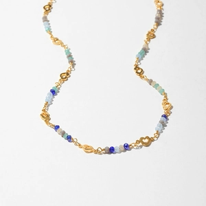 Detail of bohemian necklace featuring gold heart charms and colorful faceted beads