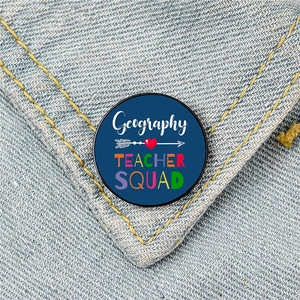 Geography Teacher Squad enamel lapel pin on denim jacket pocket, round blue metal brooch gift