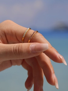 Close-up of sparkling gold plated adjustable rings with pink and white zircon stones