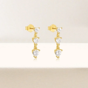 Detail of gold S925 silver earrings with three tiered heart-shaped zirconia stones
