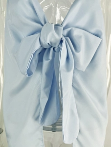 Detail of light blue satin bow tie with smooth texture and elegant stitching