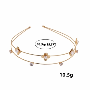 Double-layer golden flower headband with pearls and clovers on a clean background
