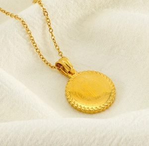 Macro view of gold St. Benedict medal pendant with detailed religious embossing