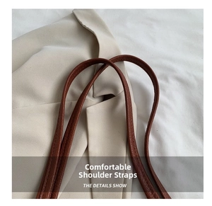 Close-up detail of soft brown leather shoulder strap with visible lychee texture on tote bag