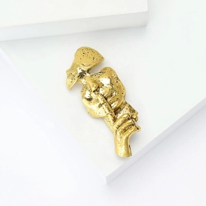 Retro gold alloy bust brooch with textured finish on a white geometric stand