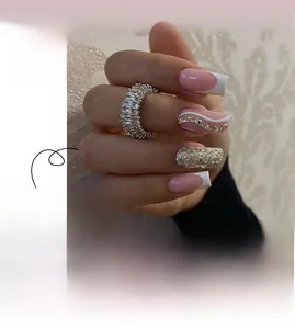 Close-up of French press-on nails with silver glitter, pink tips, and rhinestone accents