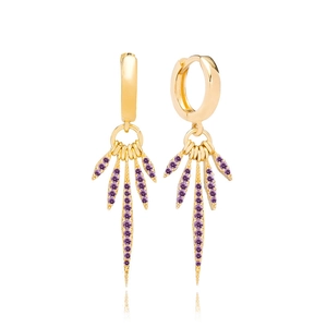 Détail de boucles d'oreilles dorées avec zircons violets et design de feuilles radiales