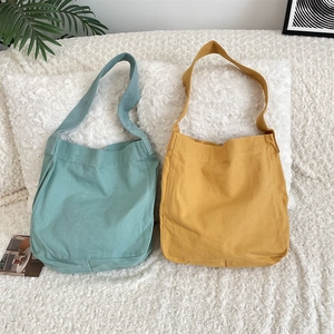 Dettaglio delle borse tote in tela verde menta e giallo zenzero su sfondo di peluche