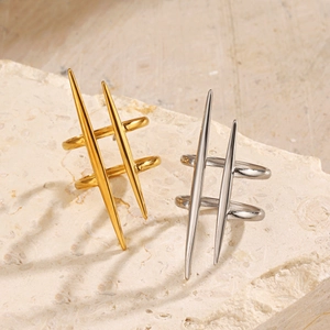Minimalist double spike gold and silver stainless steel rings on natural stone base