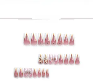 Detail view of pink gradient press-on nails with 3D white flowers and golden glitter