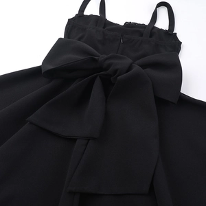 Détail du dos de la robe noire avec un grand nœud décoratif et fermeture éclair